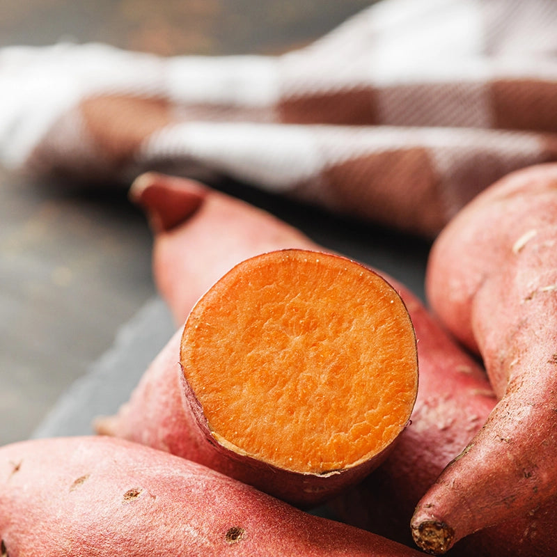 Orangene Süßkartoffeln liegen auf dem Tisch